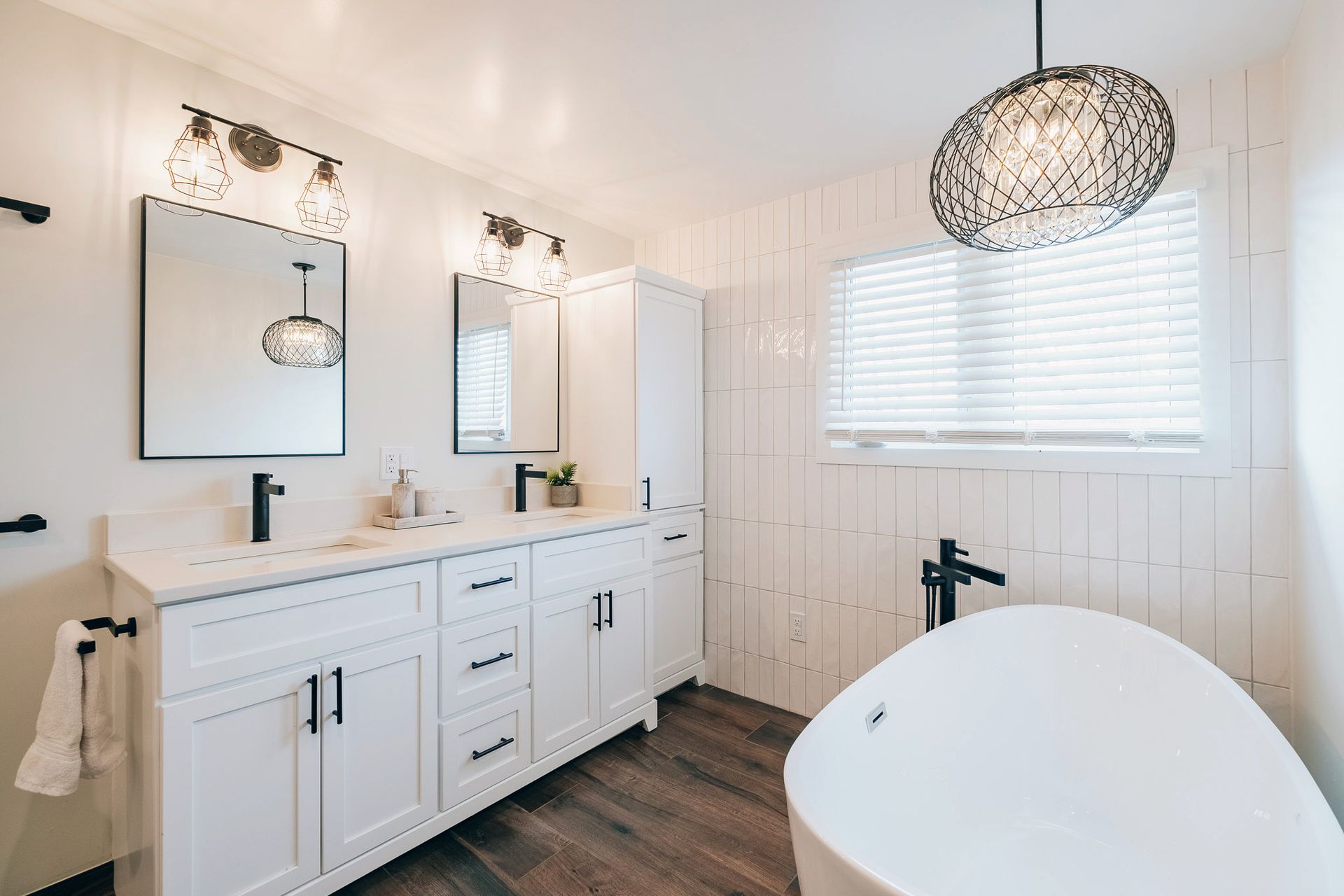 A bathroom with two sinks, two mirrors and a bathtub.