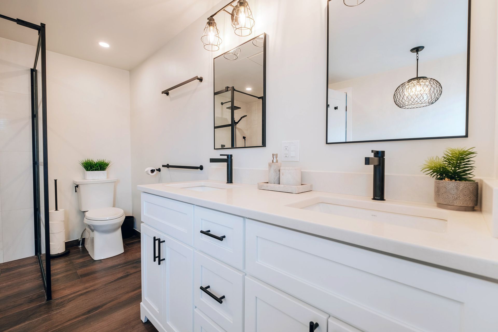 A bathroom with a toilet, sink and mirror.