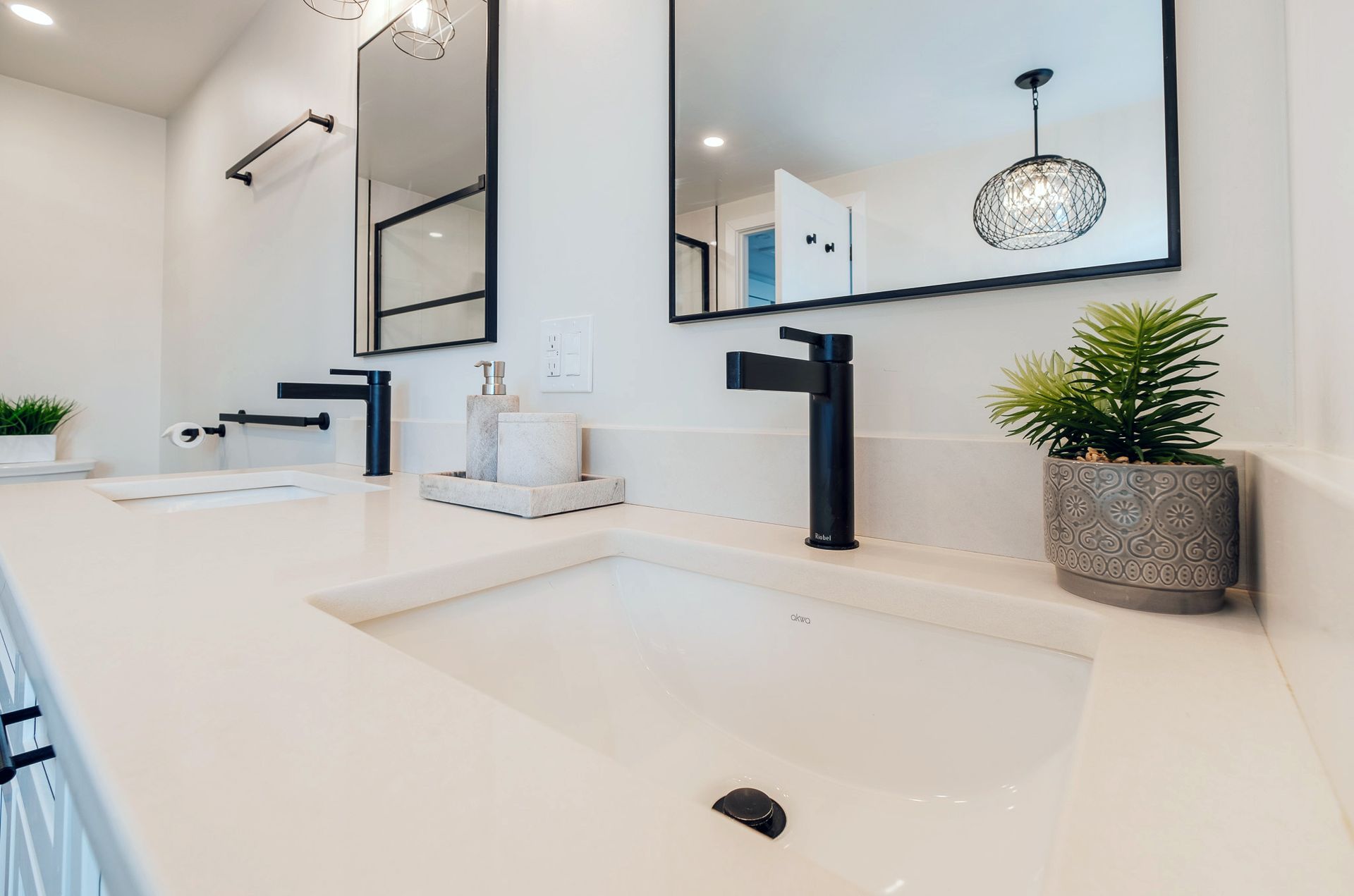 A bathroom with two sinks and two mirrors.