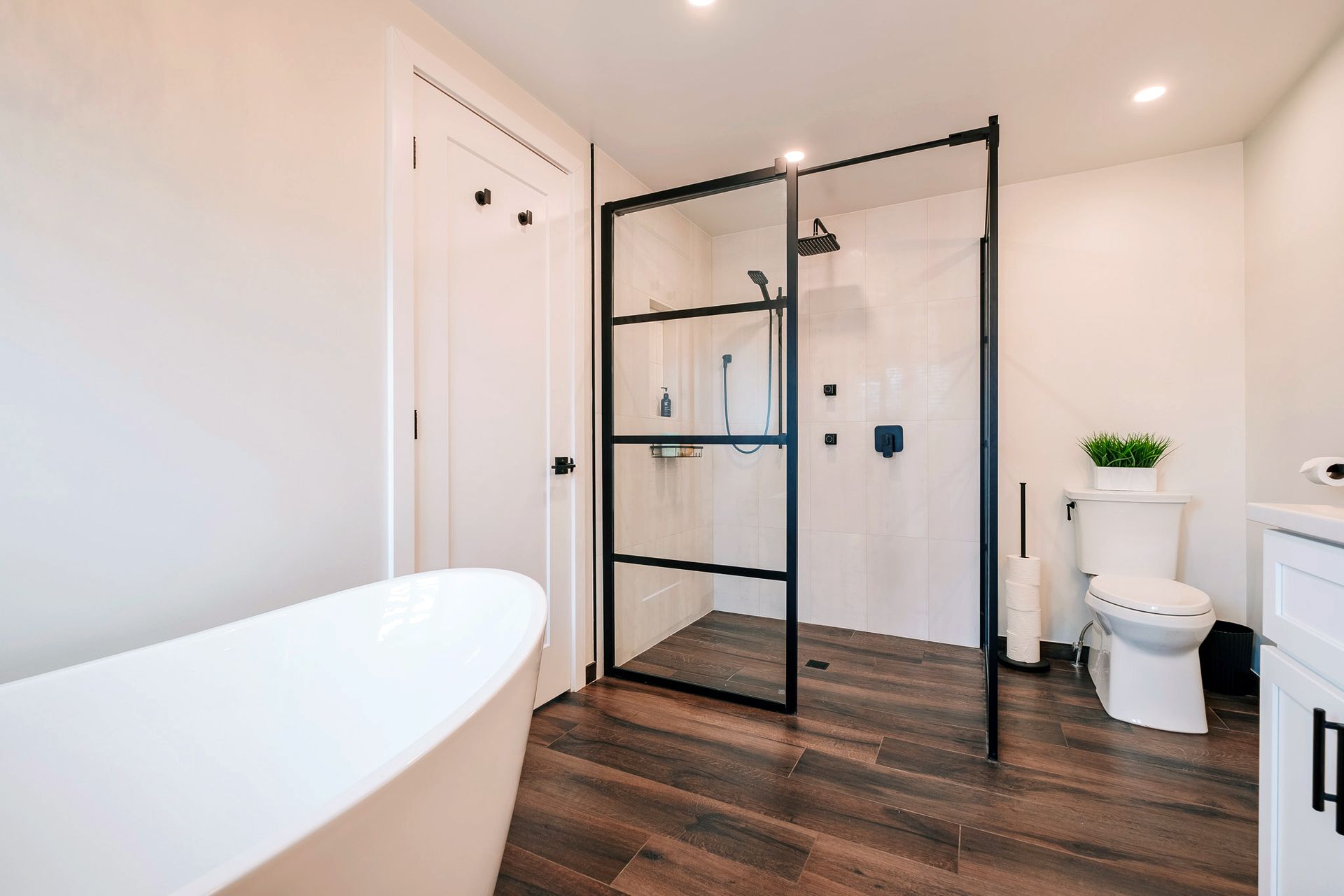 A bathroom with a bathtub, toilet, and walk in shower.