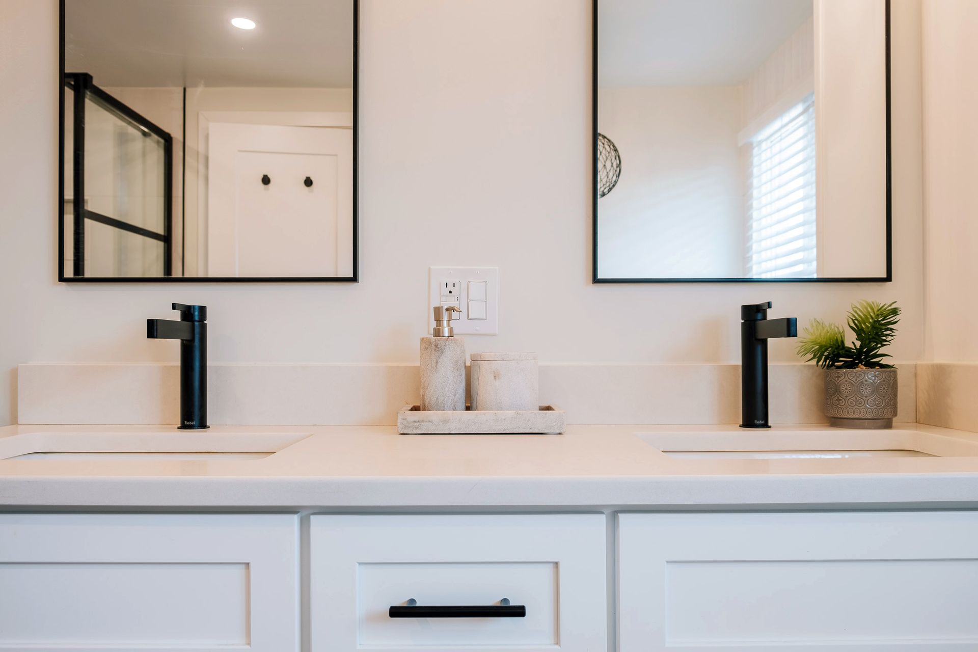 A bathroom with two sinks and two mirrors.