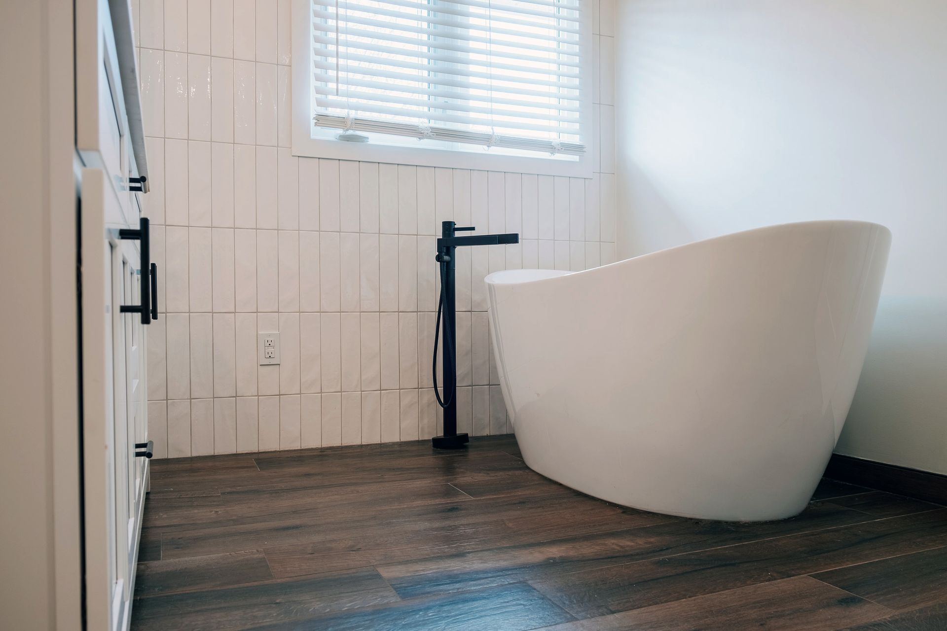 A bathroom with a freestanding tub and a window.