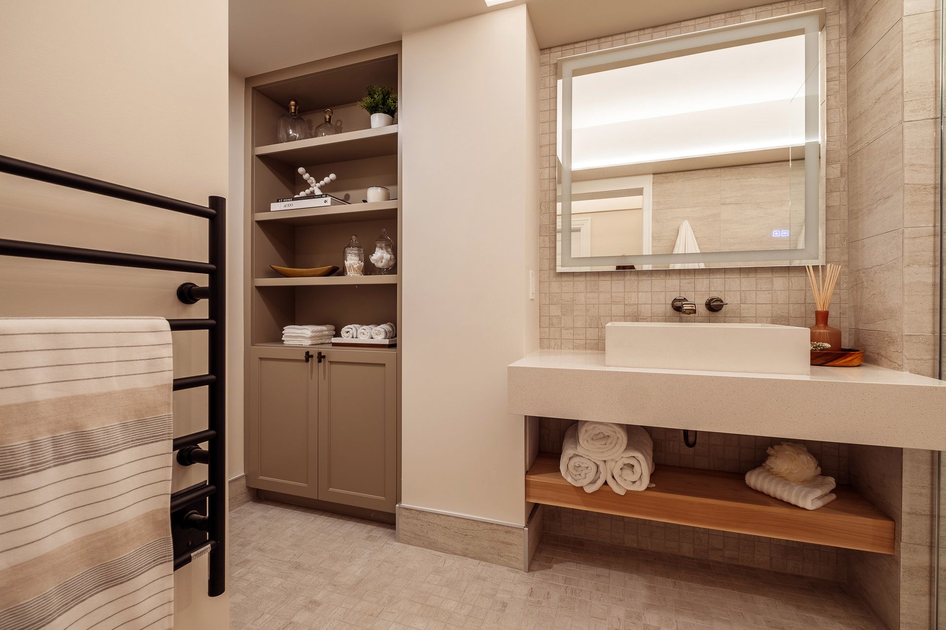 A bathroom with a sink, mirror and towel rack.