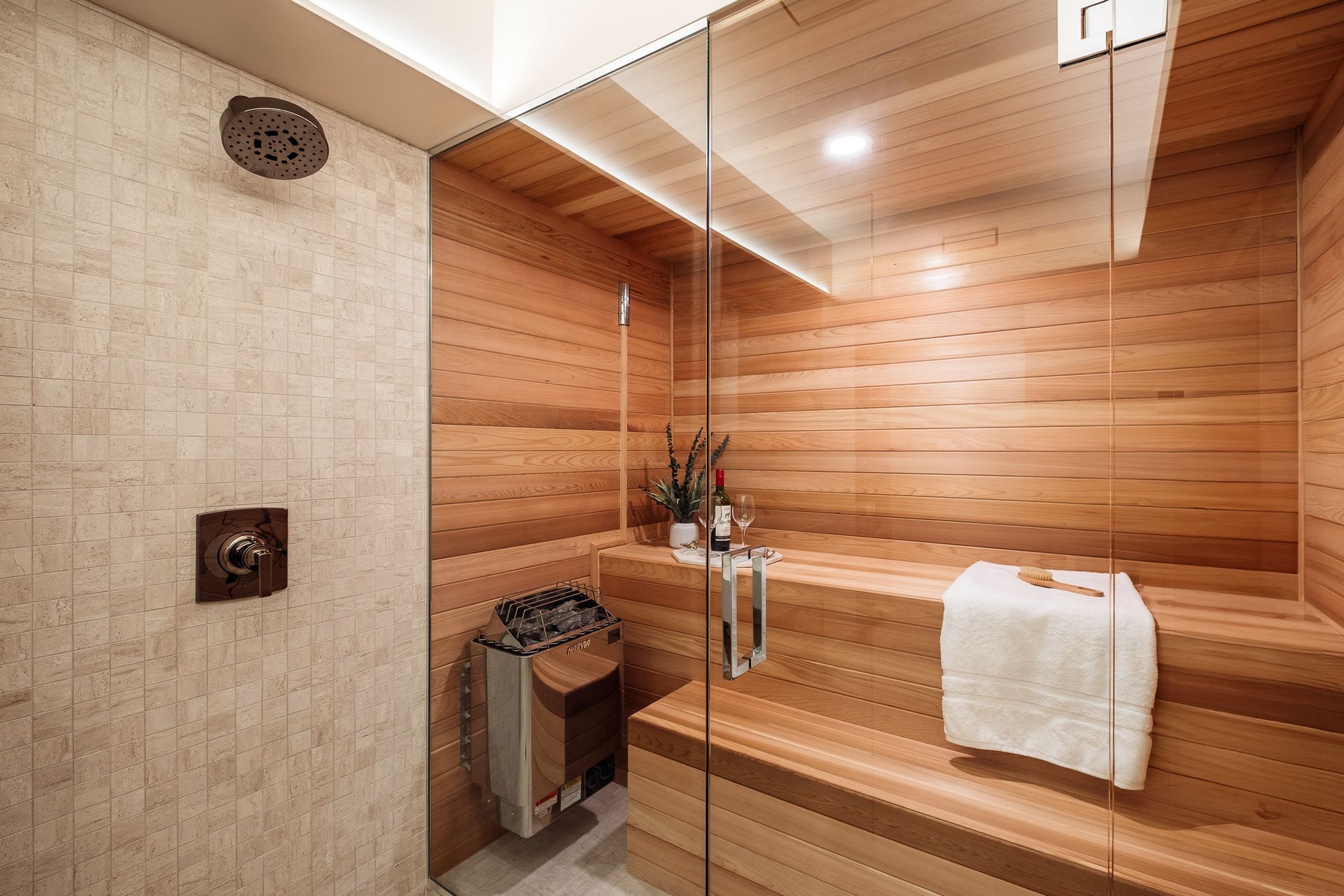 A bathroom with a wooden sauna and a glass shower.
