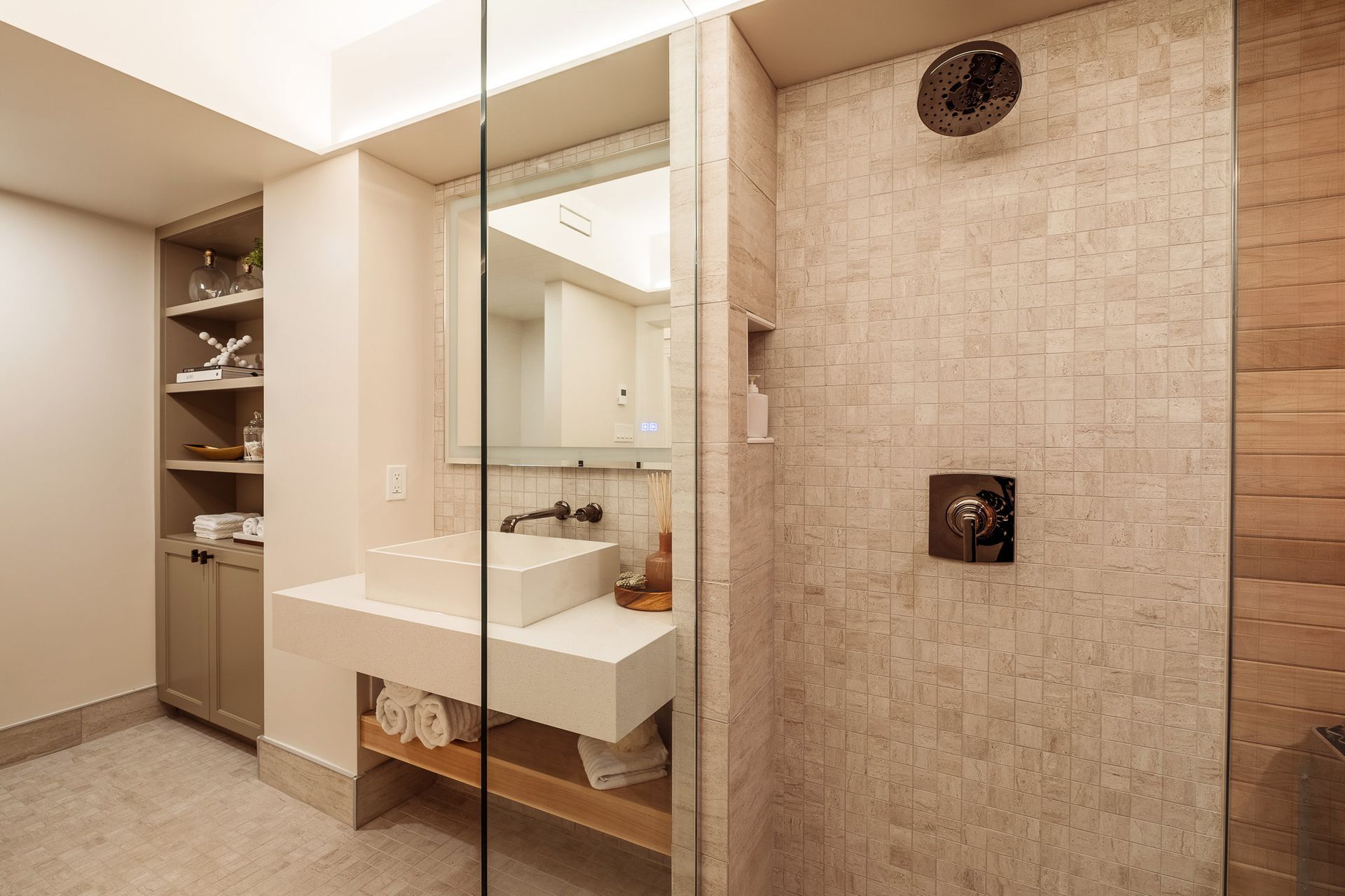 A bathroom with a sink and a walk in shower.