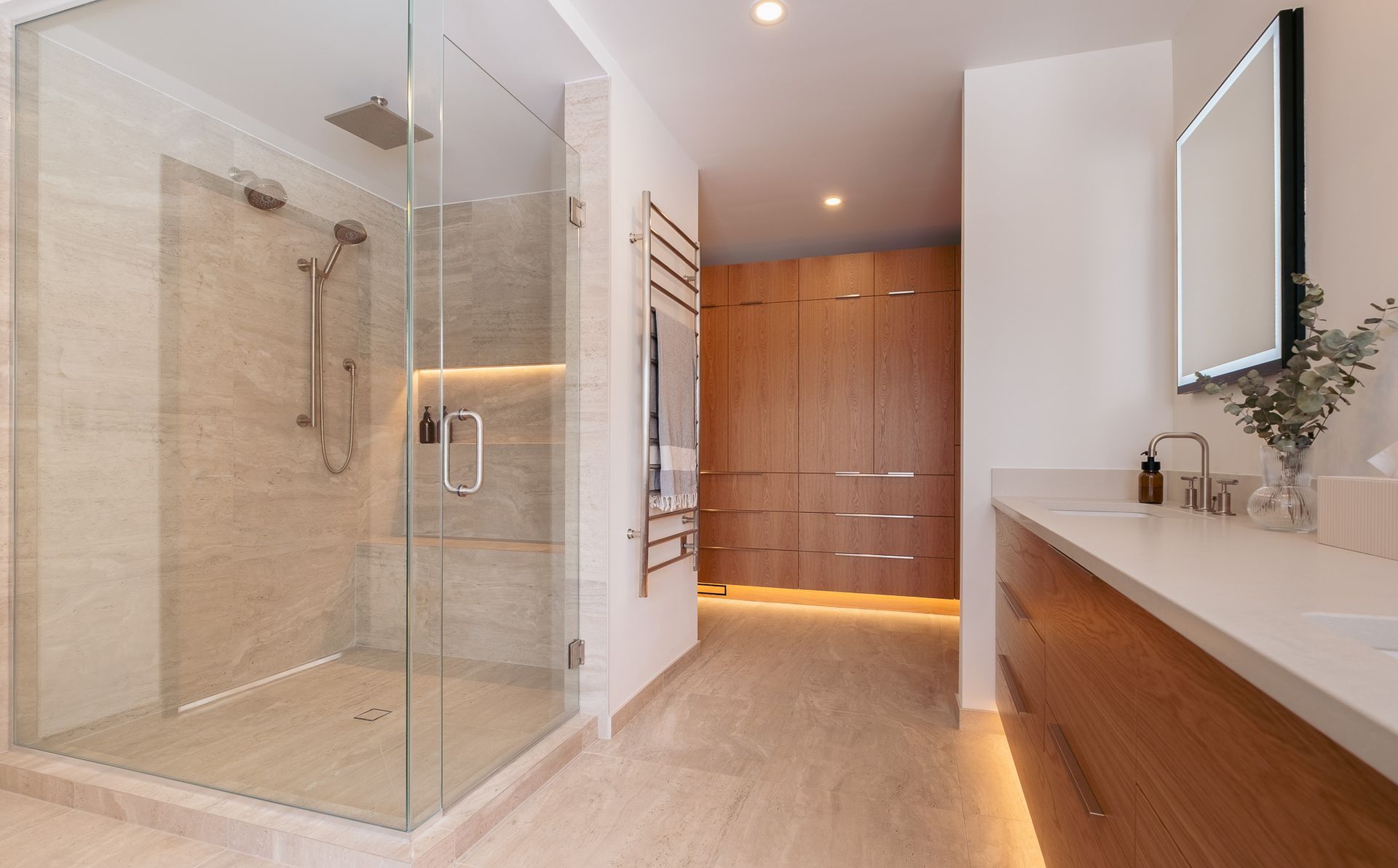 A bathroom with a walk in shower, sink and mirror.