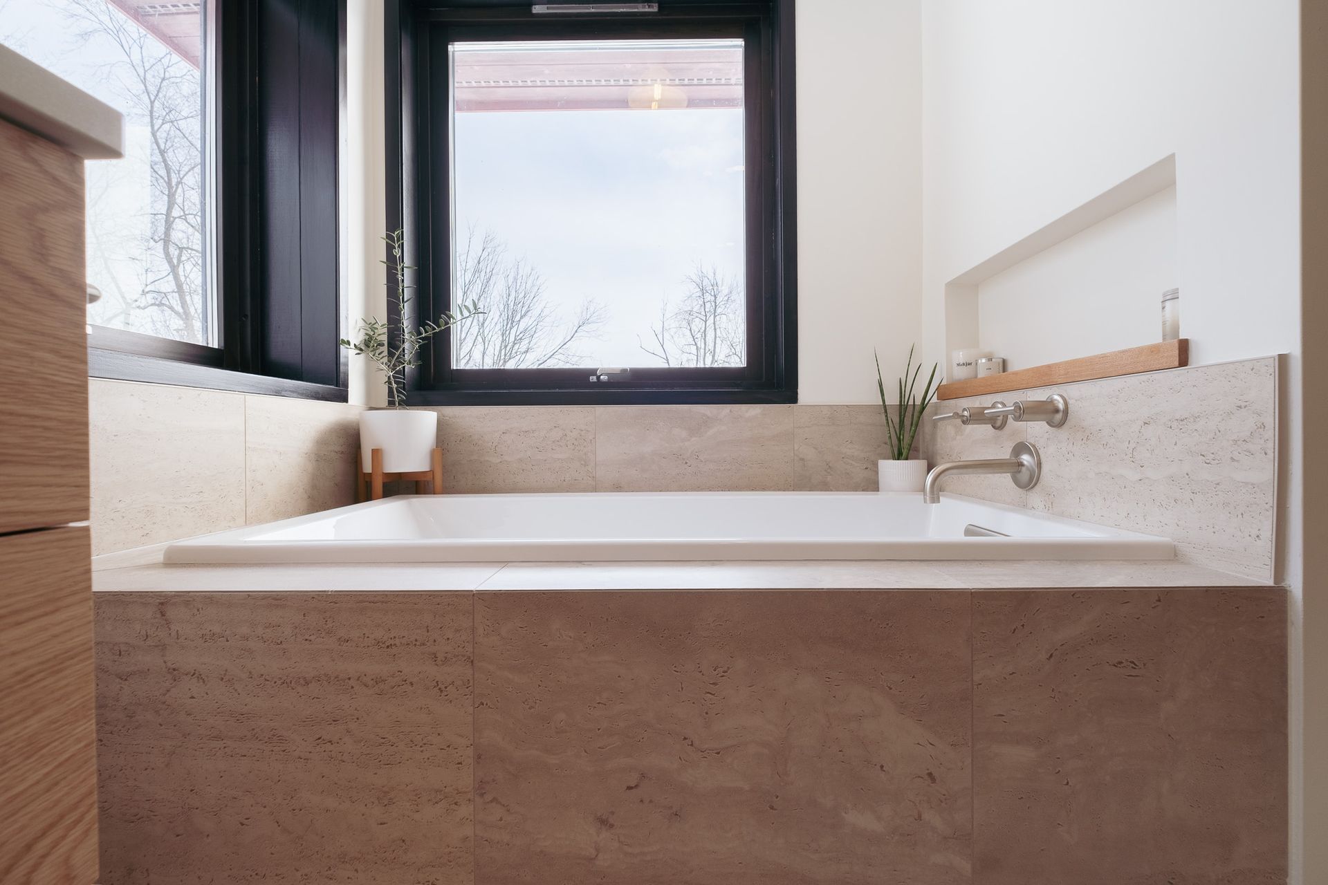 A bathroom with a bathtub and a window.