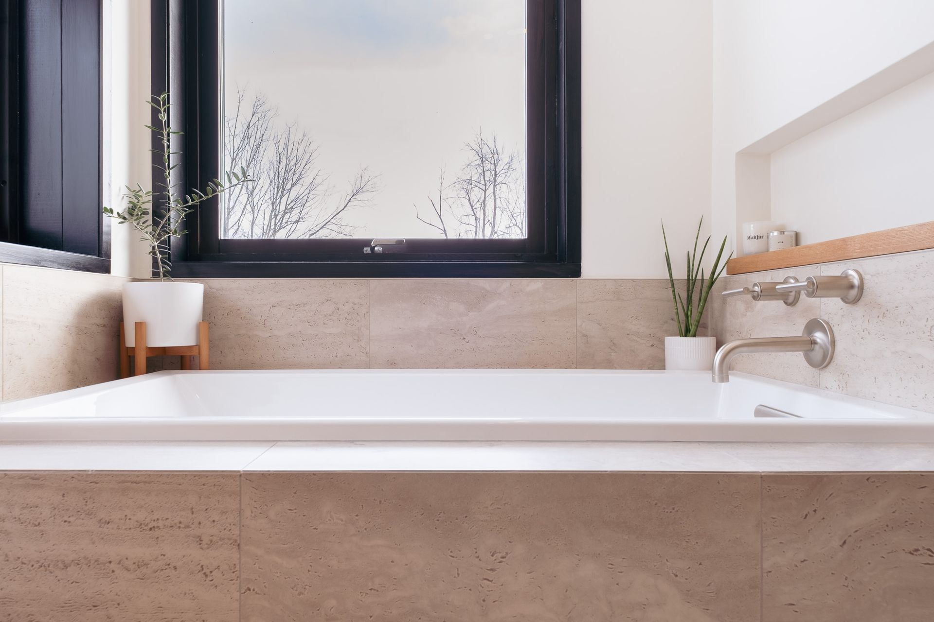 A bathroom with a bathtub and a window.