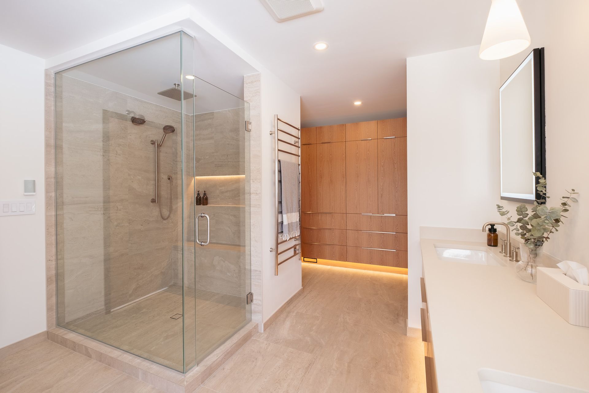 A bathroom with a walk in shower and a sink.