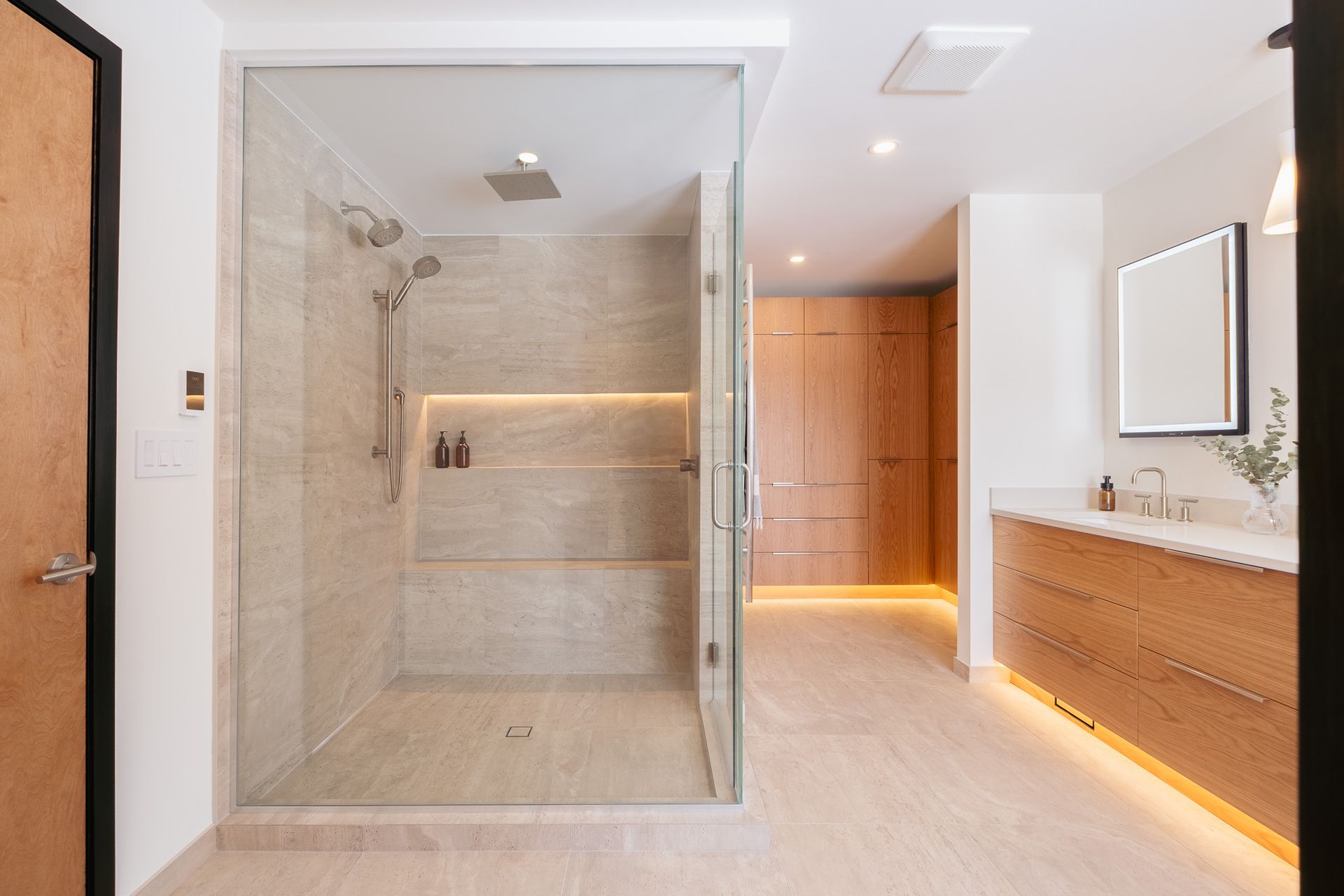 A bathroom with a walk in shower and a sink.