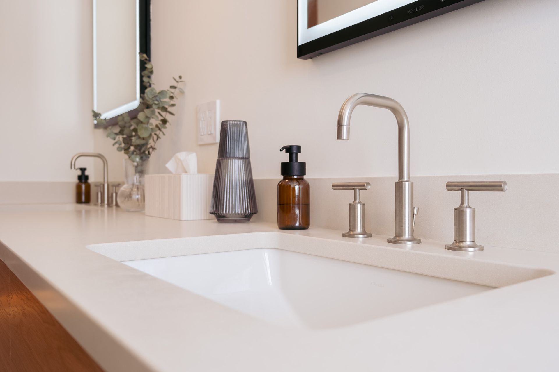 A bathroom sink with a mirror and soap on the counter.