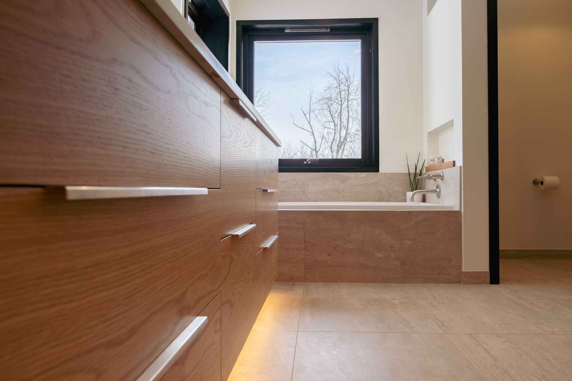 A bathroom with a bathtub and a window.