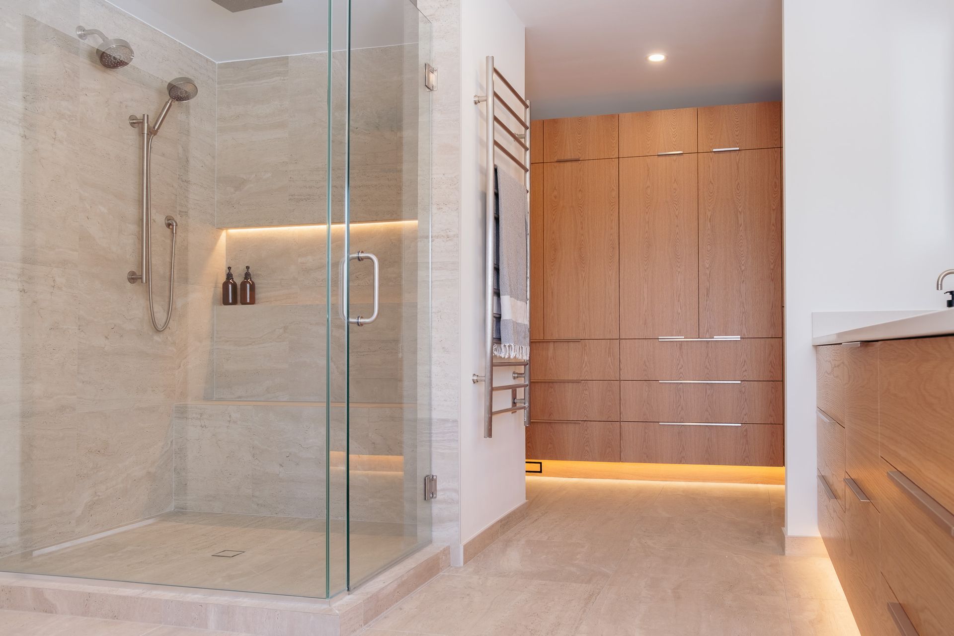 A bathroom with a walk in shower and a sink.