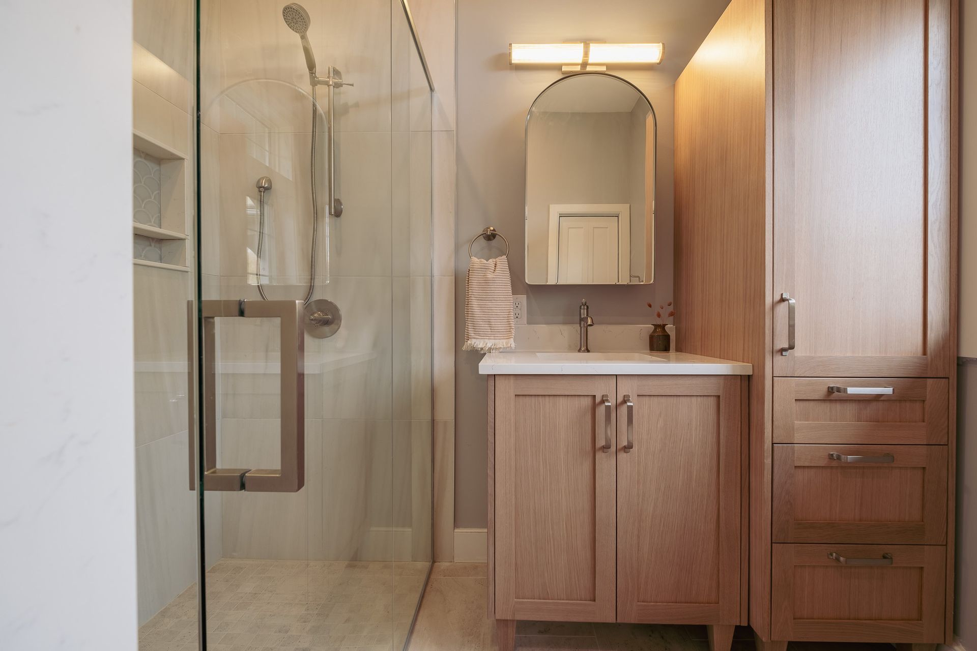 A bathroom with a walk in shower and sink.