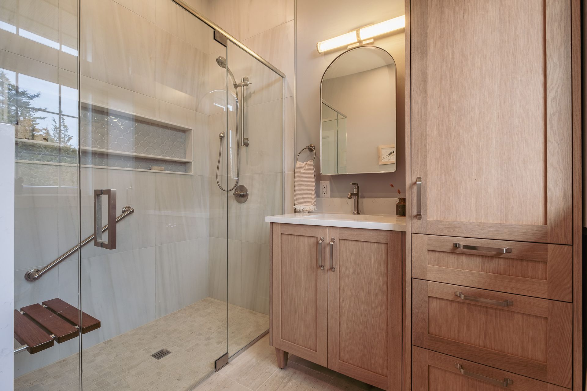 A bathroom with a walk in shower and sink.