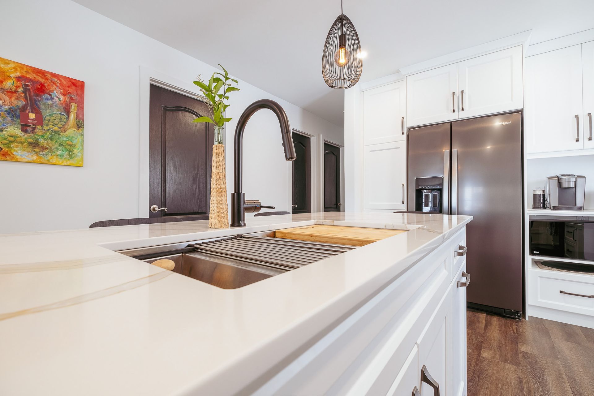 A kitchen with white cabinets and a stainless steel refrigerator.