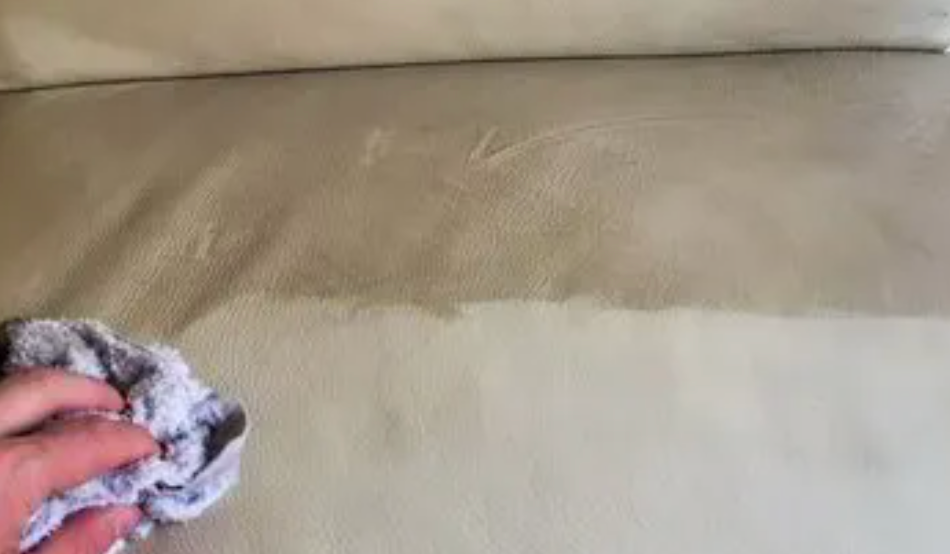 A Light Leather Couch Is being Cleaned by a Blue cloth — Carpet Pro Care in Goonellabah, NSW