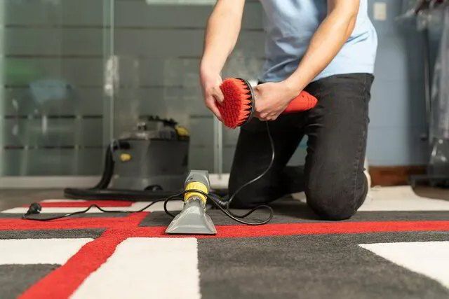 A Person is Cleaning a Rug With a Vacuum Cleaner — Carpet Pro Care in Goonellabah, NSW