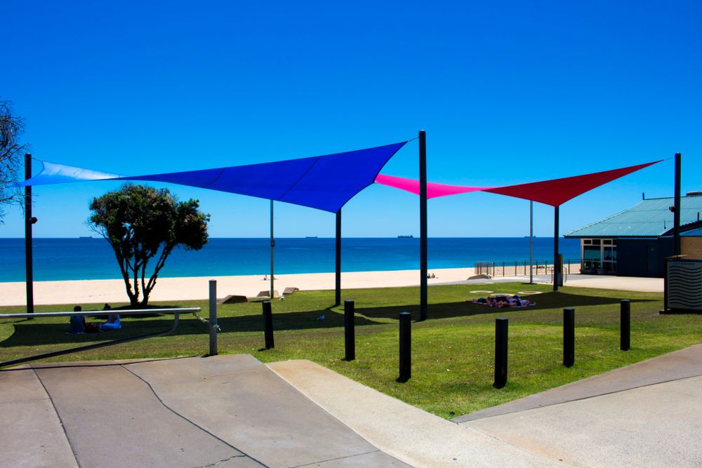 A Group of Colorful Umbrellas Are Sitting in Front of a Beach — Cooloola Sail Company In Curra, QLD