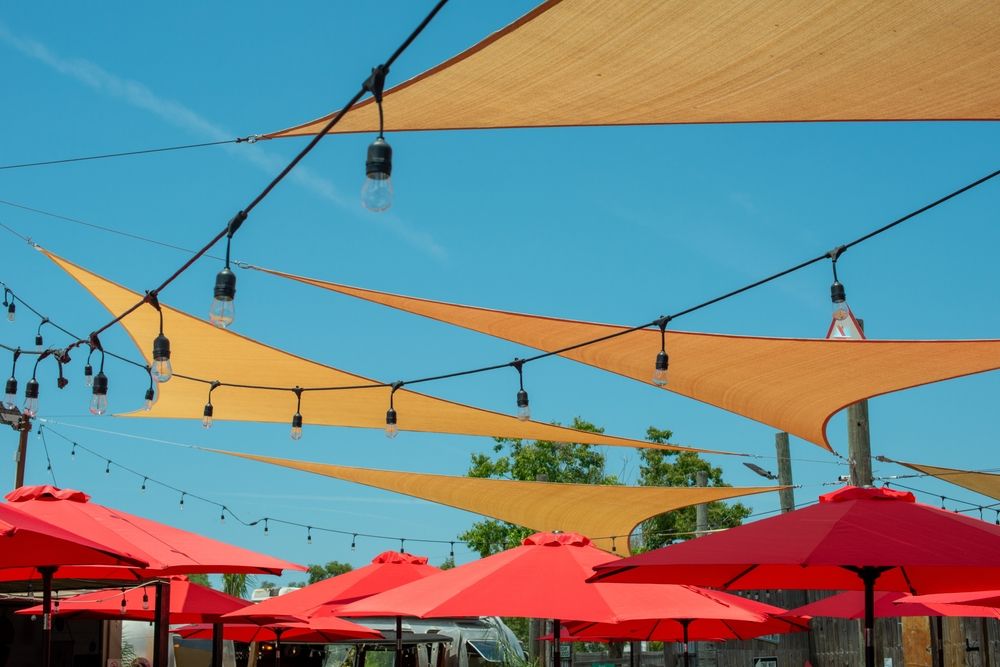 A Bunch of Umbrellas Are Hanging From the Ceiling of a Restaurant — Cooloola Sail Company In Southside, QLD