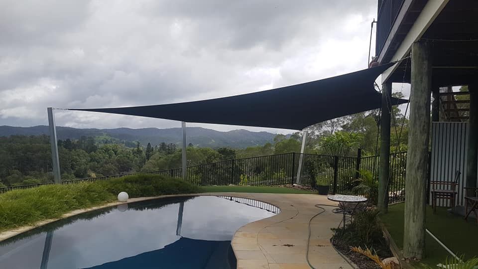 A Large Swimming Pool With a Shade Sail Over It — Cooloola Sail Company In Pomona, QLD