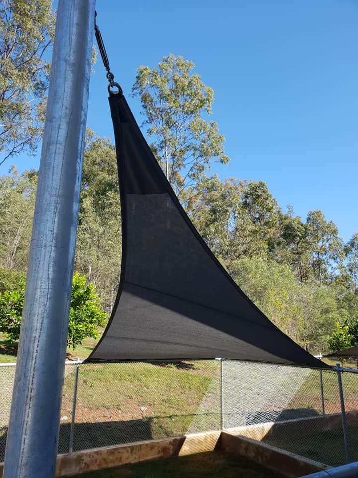 A Black Sail is Hanging From a Metal Pole — Cooloola Sail Company In Glenwood, QLD