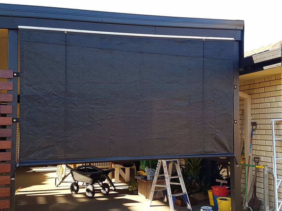 A Black Awning is Being Installed on a Garage Door — Cooloola Sail Company In Southside, QLD