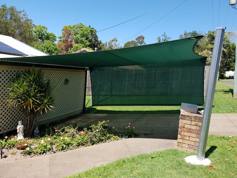 A Green Umbrella is Sitting in Front of a House — Cooloola Sail Company In Curra, QLD