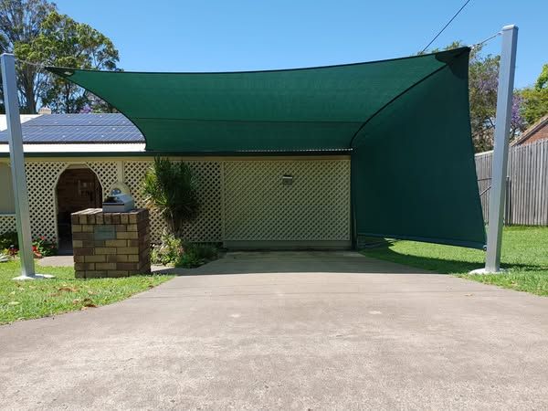 A Green Shade Covering a Driveway in Front of a House — Cooloola Sail Company In Cooloola Cove, QLD