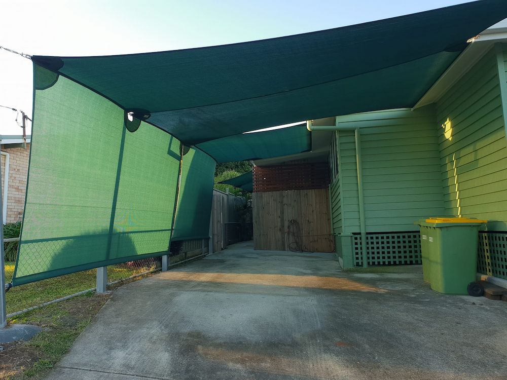 A Green Awning is Covering a Driveway in Front of a House — Cooloola Sail Company In Eumundi, QLD