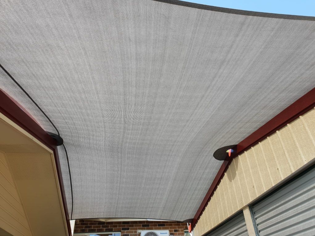 A Gray Shade Sail is Hanging From the Ceiling of a Building — Cooloola Sail Company In Cooroy, QLD