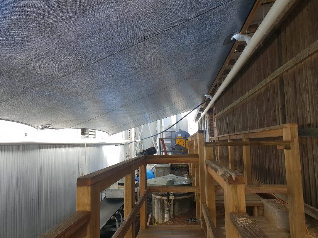 A Wooden Walkway Leading to a Building With a Blue Tarp Covering the Ceiling — Cooloola Sail Company In Tamaree, QLD