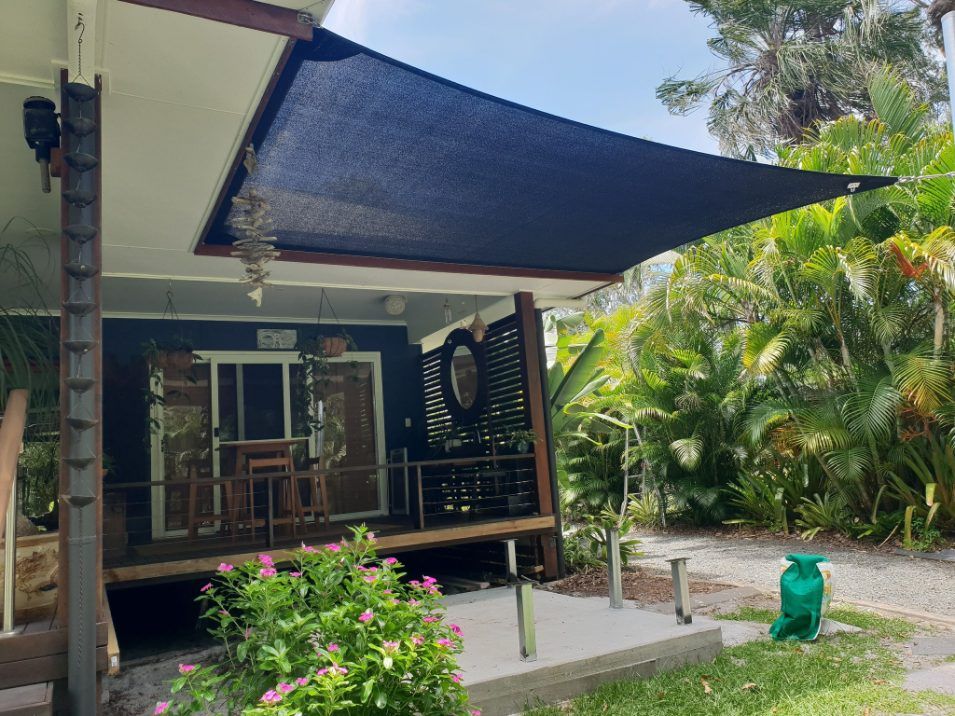 A Black Shade Sail is Covering the Porch of a House — Cooloola Sail Company In Curra, QLD