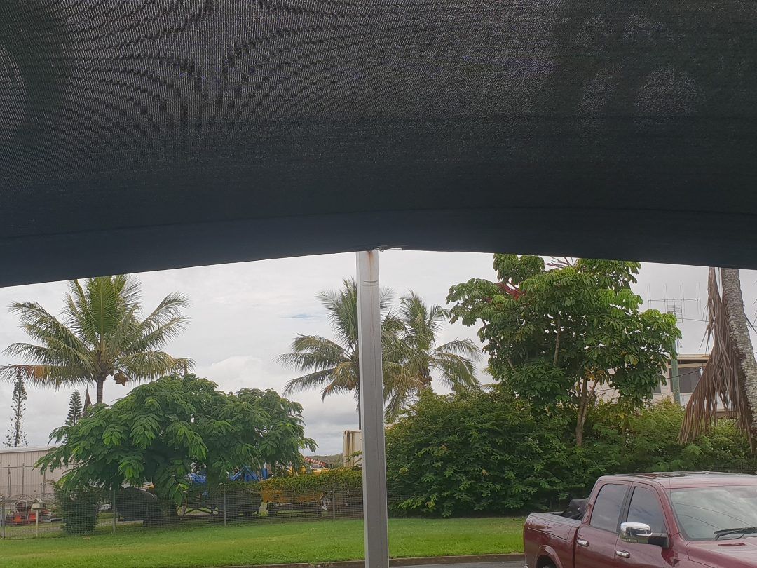 A Red Truck is Parked Under an Umbrella in a Parking Lot — Cooloola Sail Company In Eumundi, QLD