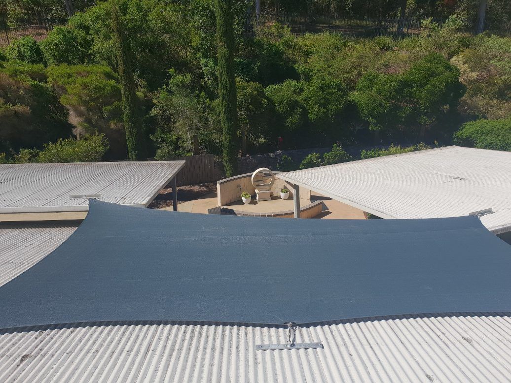 A Large Black Umbrella is Sitting on Top of a Roof — Cooloola Sail Company In Kilkivan, QLD