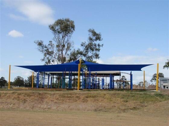 A Blue Umbrella Over a Playground With a Tree in the Background — Cooloola Sail Company In Glenwood, QLD