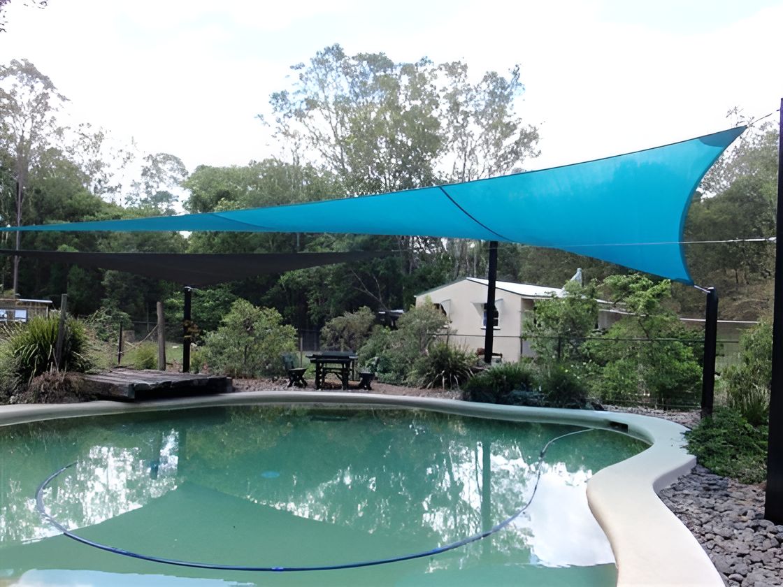 A Blue Shade Sail is Covering a Large Swimming Pool — Cooloola Sail Company In Southside, QLD