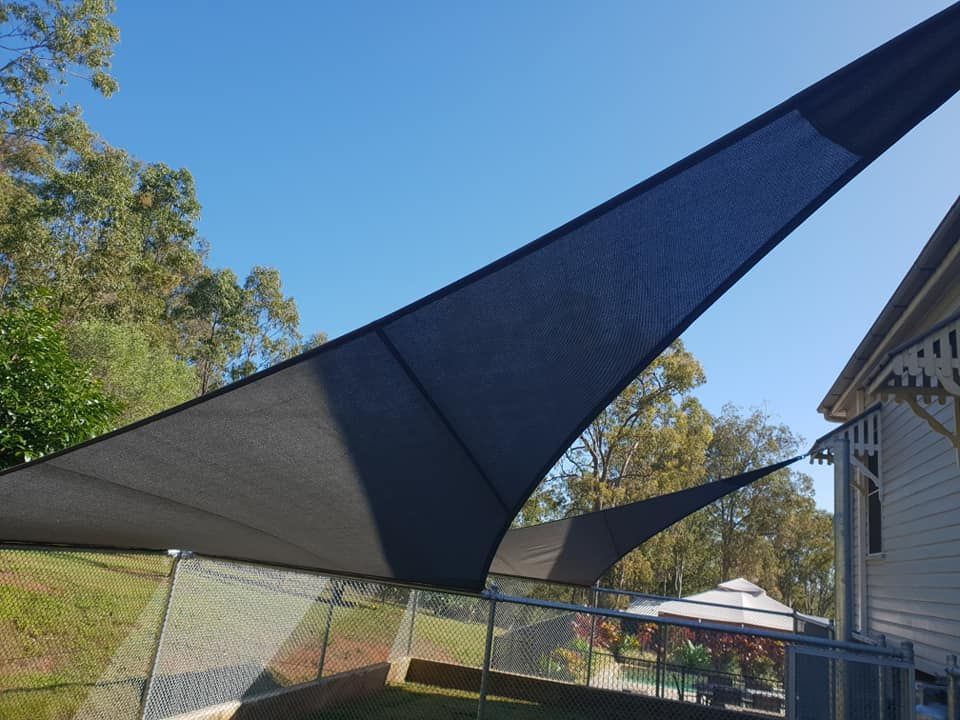A Large Black Umbrella is Sitting in Front of a House — Cooloola Sail Company In Southside, QLD
