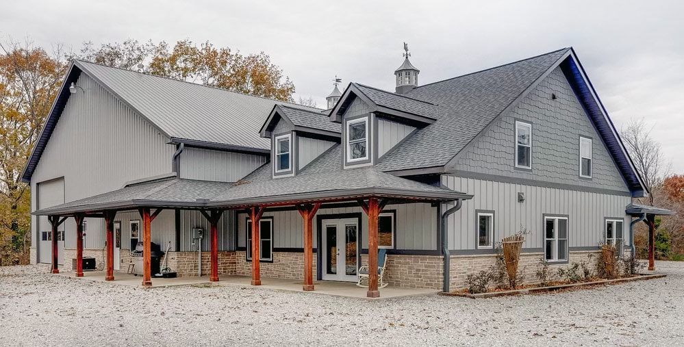 Barndominium with stone and metal siding combination with a standard shingled roof. 