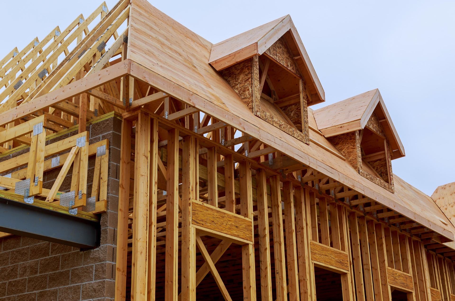 Get Started Today! A house is being built with wooden beams and a roof.