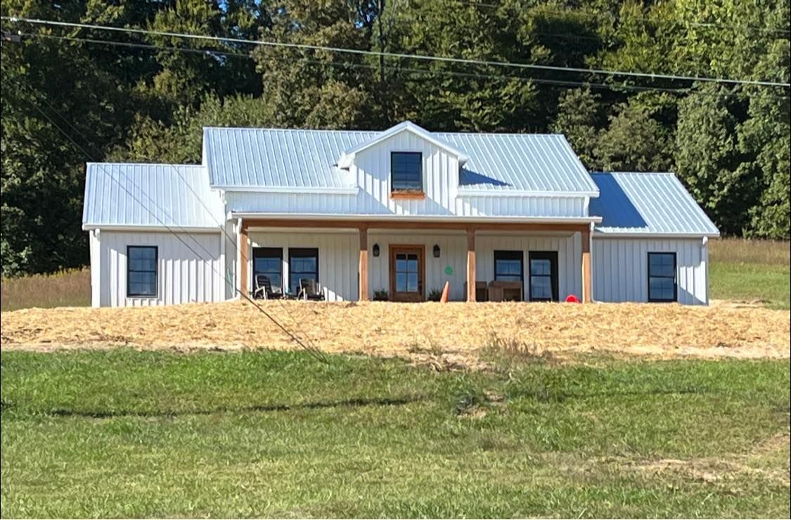 A Frame Barndominium built in the woods with a new Bronco parked out front giving rustic vibes