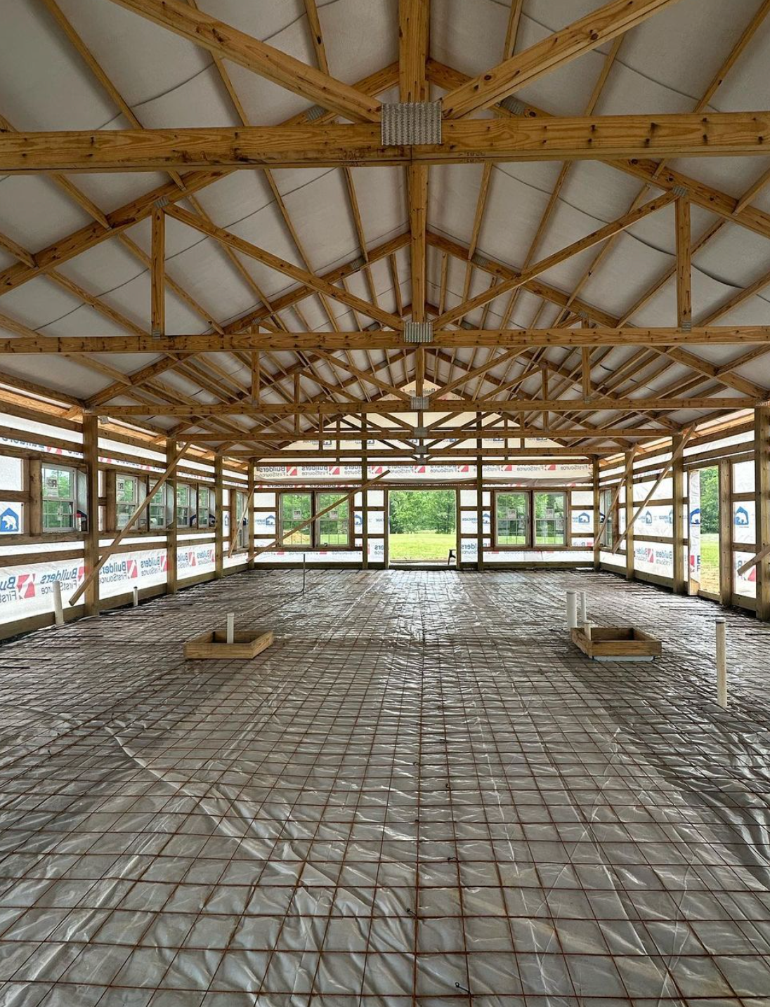 Barndominium under construction - interior shot showing roof framing and tall ceilings that will soon be installed
