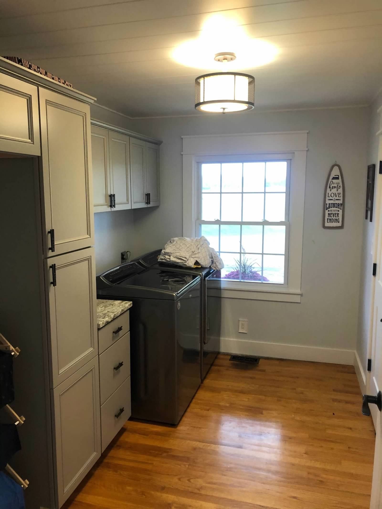 A laundry room with a washer and dryer and a window.