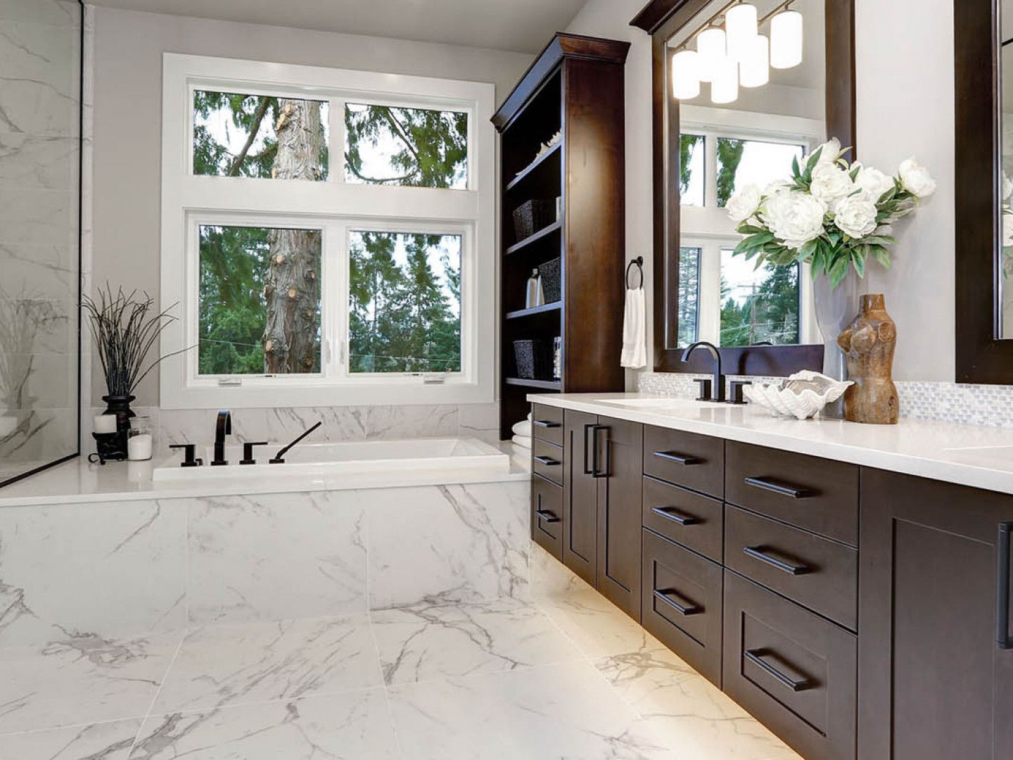 A bathroom with a bathtub , sink , mirror and window.