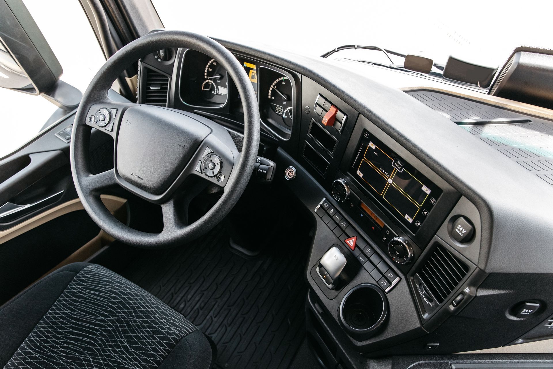 Car interior with steering wheel, dashboard, and center console with digital controls