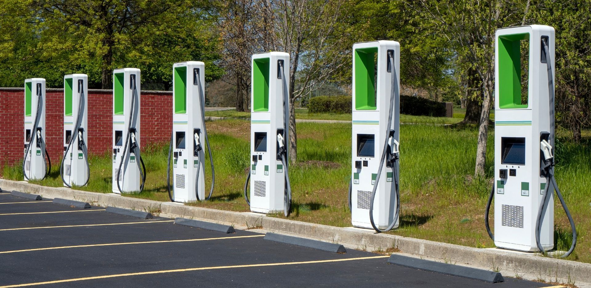 Une rangée de bornes de recharge pour véhicules électriques dans un parking.