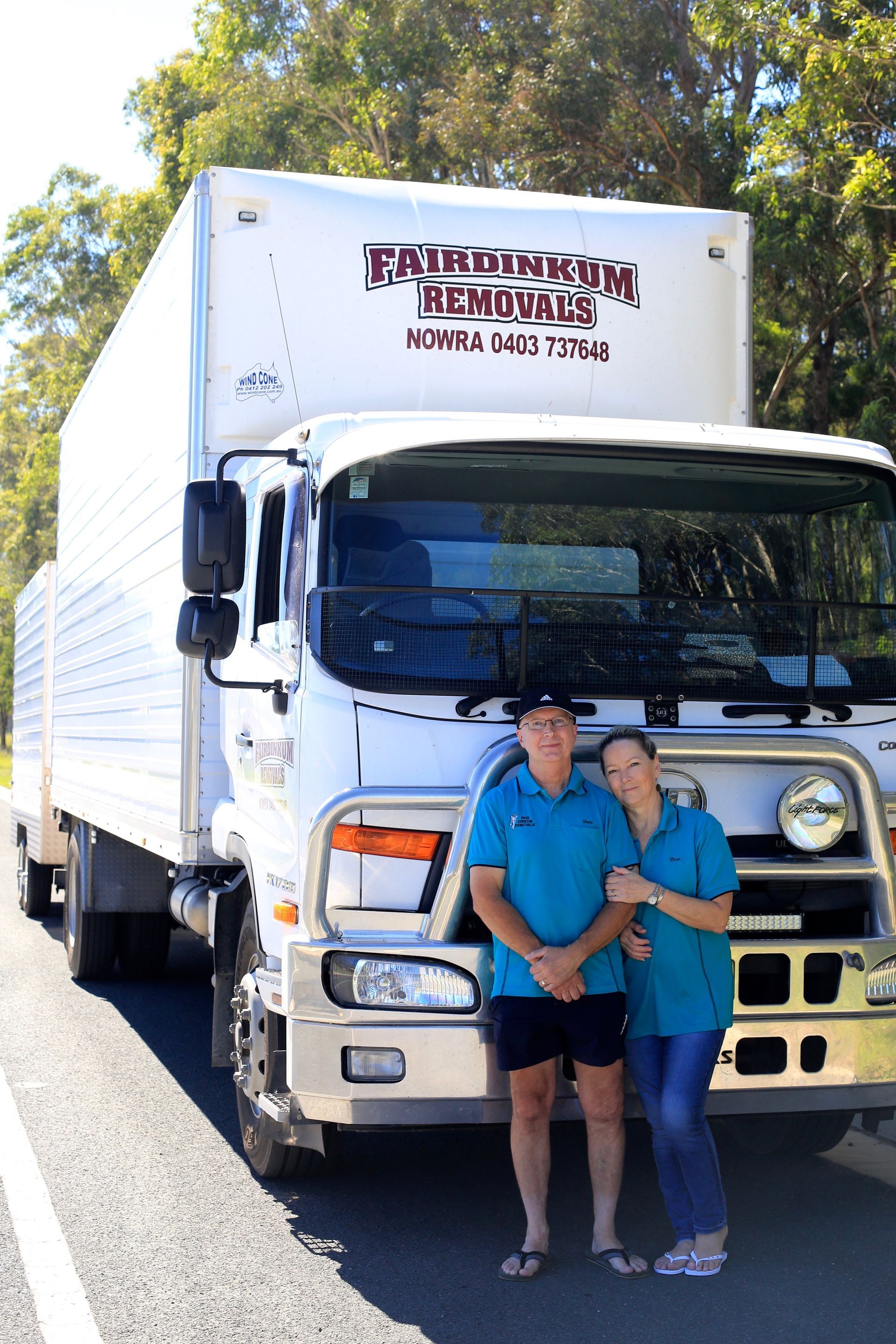 A Man And Women Standing In Front Of a Moving Truck — Fairdinkum Removals In Nowra, NSW