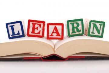 Colorful letter blocks spelling “LEARN” on an open book