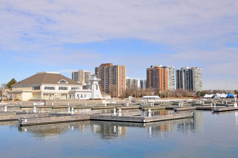 Marina with buildings in the background under a blue sky. White and beige building is on the left.