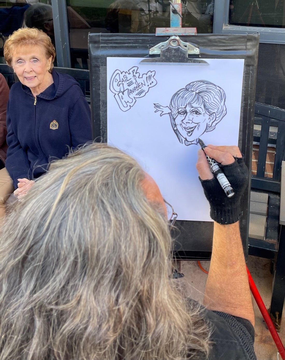 A man is drawing a picture of a woman on a clipboard